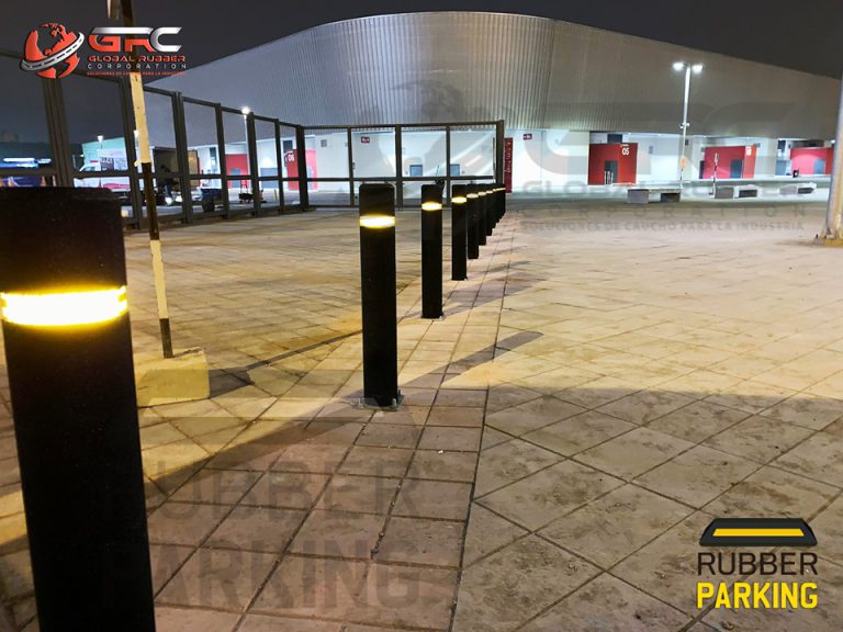 Bolardos de caucho con banda reflectiva instalados en una plaza de noche
